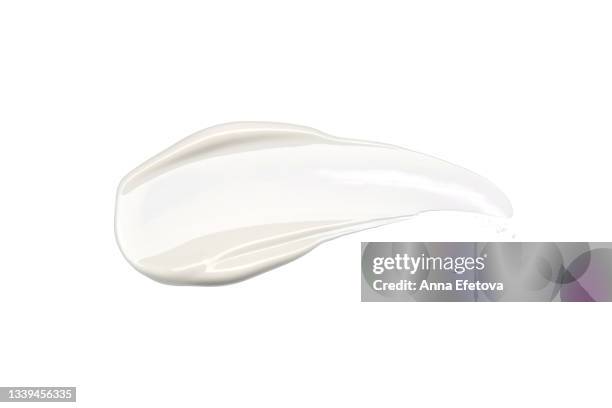 smooth cosmetic smear of white cream isolated on white background. concept of health and wellbeing. flat lay style with copy space - nata fotografías e imágenes de stock