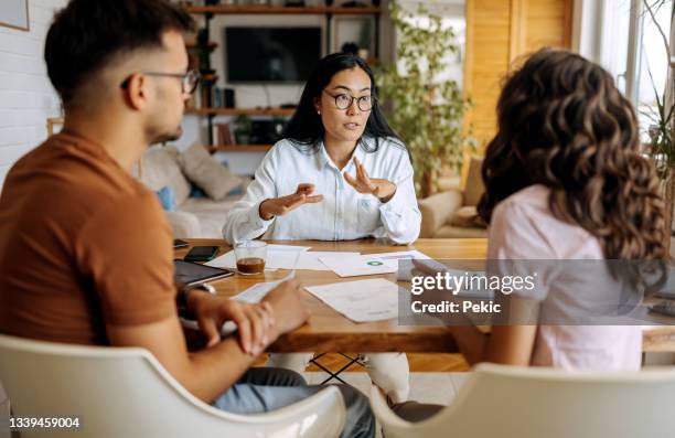 jeune couple recevant des conseils d’experts financiers - mortgage loan photos et images de collection