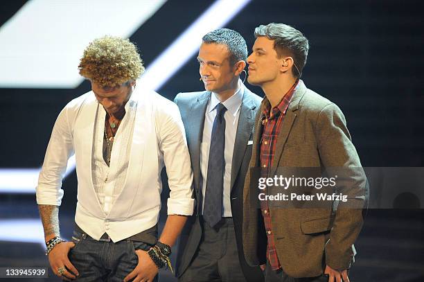 Jury member Till Broenner and his artists Rufus Martin and David Pfeffer wait for the results during 'The X Factor Live' TV-Show on November 22, 2011...