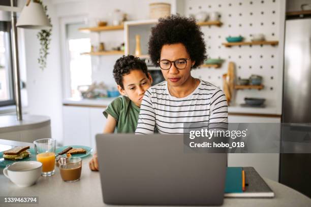 working at home is not always easy. - parent on computer stock pictures, royalty-free photos & images