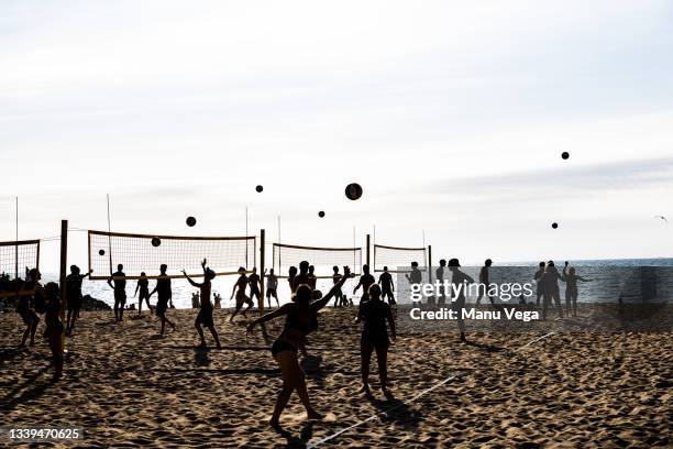 silhouettes of people playing beach volleyball on a beach on july 23, 2020 at arlet beach in the french basque country - beach volleyball group stock pictures, royalty-free photos & images