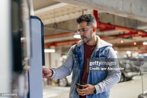 man at the parking payment counter - parquímetro imagens e fotografias de stock