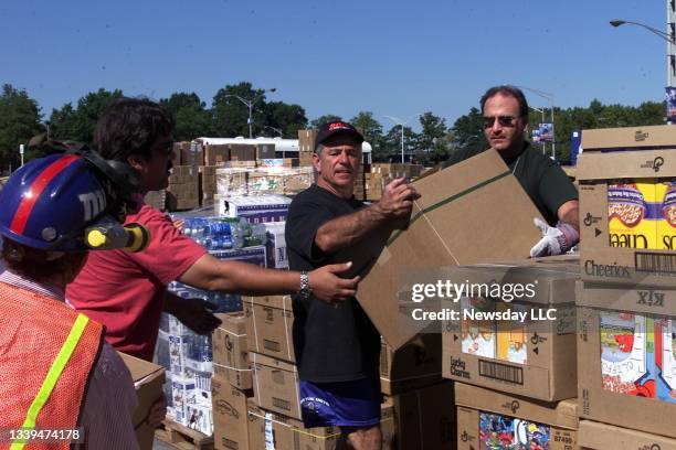 New York Mets manager Bobby Valentine helps workers with the boxes of food and supplies in the parking lot at Shea Stadium in Flushing, New York on...