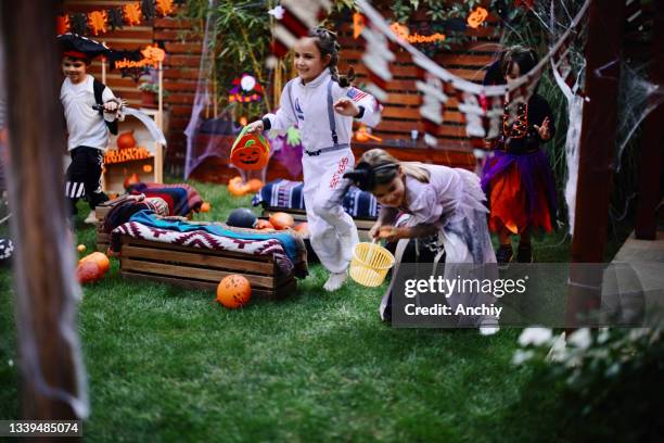 mignons petits enfants jouant au jeu d’halloween de chasse au trésor lors d’une fête dans la cour - chasse au trésor photos et images de collection