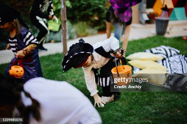 mignons petits enfants jouant au jeu d’halloween de chasse au trésor lors d’une fête dans la cour - chasse au trésor photos et images de collection