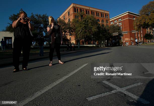 People photograph an "x" on Elm street where John F. Kennedy was assassinated near the former Texas School Book Depository, now the Dallas County...