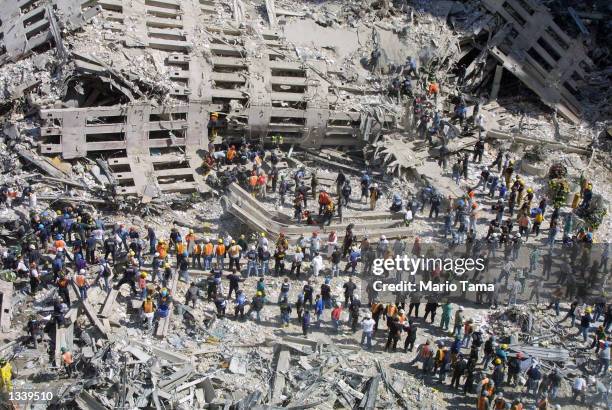 Rescue workers sift through the wreckage of the World Trade Center September 13, 2001 in New York City, two days after two hijacked airplanes slammed...