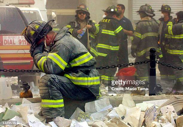 Firefighter Gerard McGibbon, of Engine 283 in Brownsville, Brooklyn, prays after the World Trade Center buildings collapsed September 11, 2001 after...