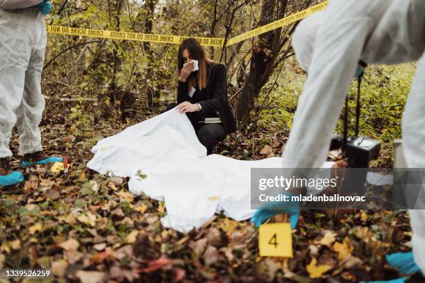 group of people, crime scene investigation, police and forensics doing their jobs, there is a dead body in the forest. - dead body blood stock pictures, royalty-free photos & images