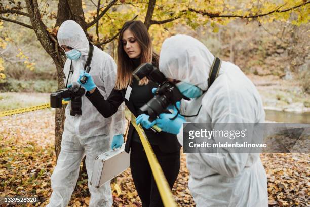 group of people, crime scene investigation, police and forensics doing their jobs, there is a dead body in the forest. - dead body blood stock pictures, royalty-free photos & images