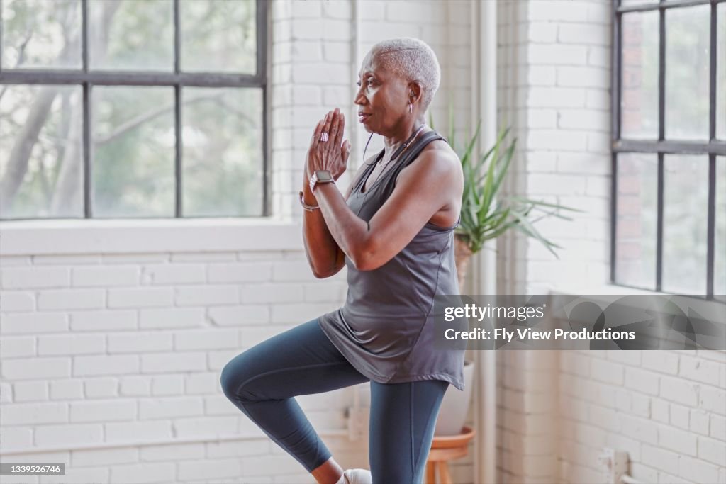 Mujer mayor activa haciendo yoga en casa