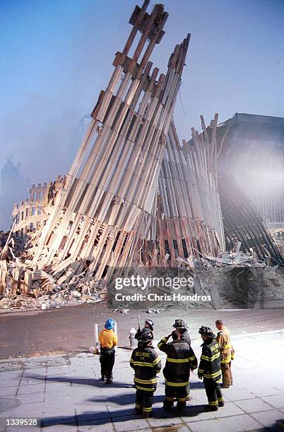 New York City firefighters look at the destroyed facade of the World Trade Center September 13 two days after the twin towers were destroyed when hit...