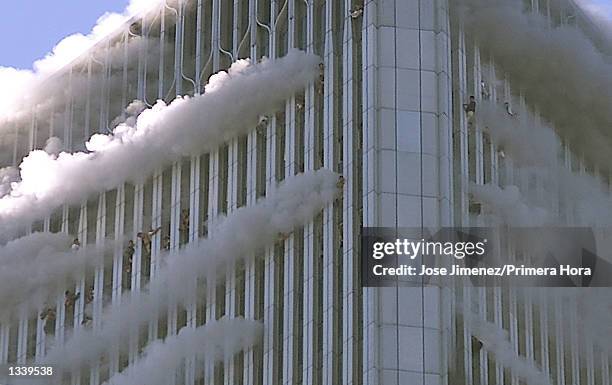 People hang from the windows of the North Tower of the World Trade Center after a hijacked airliner hit the building September 11, 2001 in New York...