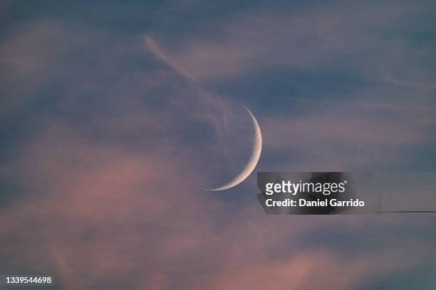 crescent moon during a sunset - moon horizon stock-fotos und bilder