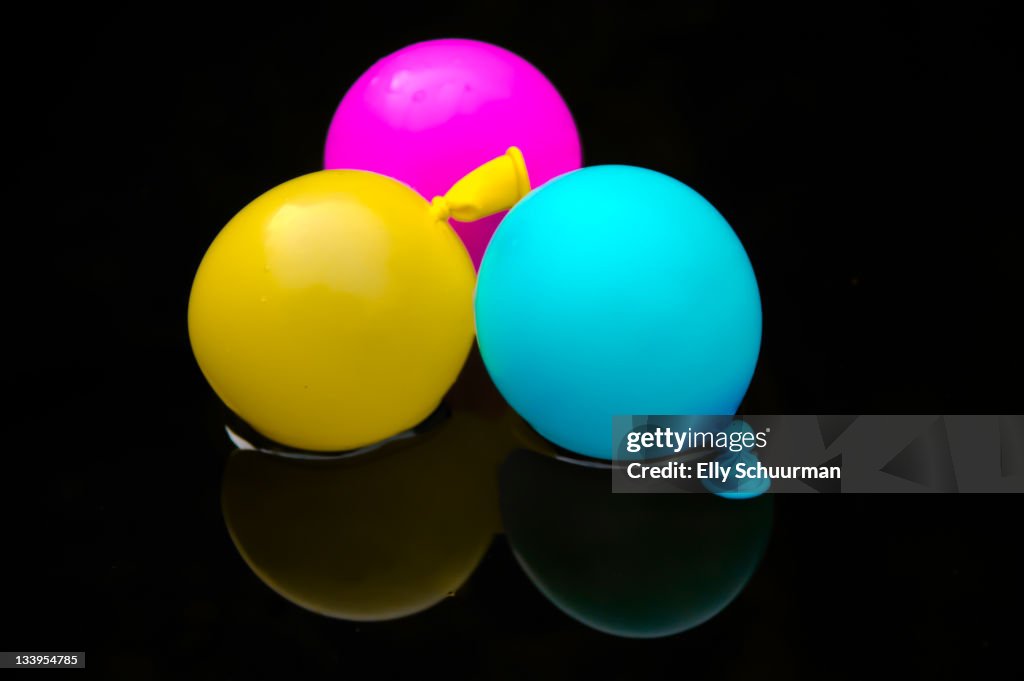 CMYK balloons on black background