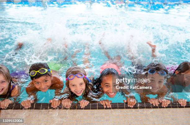 multi ethnic group of children learning to kick in the swimming pool - simma bildbanksfoton och bilder