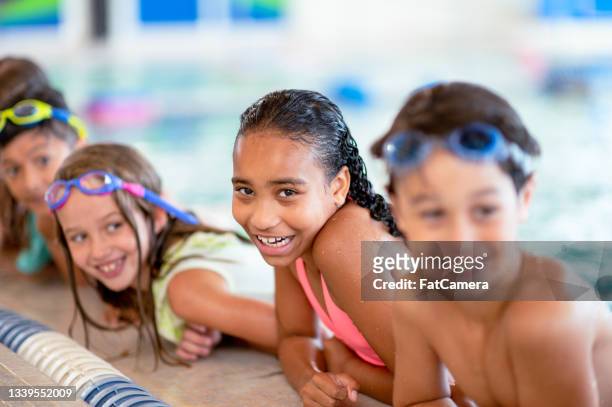 multi ethnic children at a group swimming lesson - ymca stock pictures, royalty-free photos & images