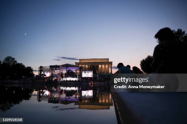 People watch the cast of the Broadway musical ‘Come From Away' perform a free concert in front of the Lincoln Memorial on September 10, 2021 in...