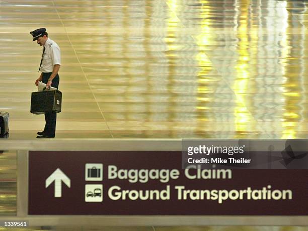 Pilot stands alone with his chart case on the empty concourse of Ronald Reagan National Airport September 18, 2001 in Virginia. Reagan National...