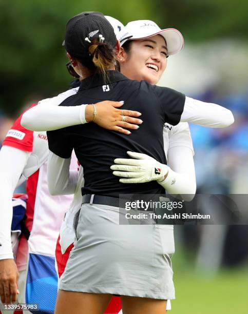 Mone Inami of Team Japan embraces with Lydia Ko of Team New Zealand after winning the silver medal on the playoff first hole on the 18th green during...