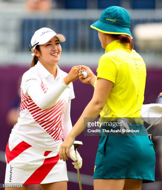 Mone Inami of Team Japan fist bumps with Hannah Green of Team Australia after holing out on the 18th green during the final round of the Women's...