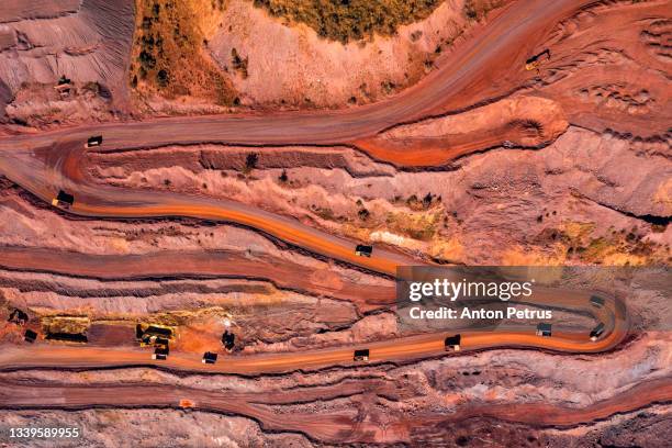 aerial view of open pit iron ore and heavy mining equipment. - mines de charbon photos et images de collection