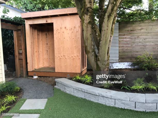 a half build shed among a nicely landscaped backyard. - build path stock-fotos und bilder