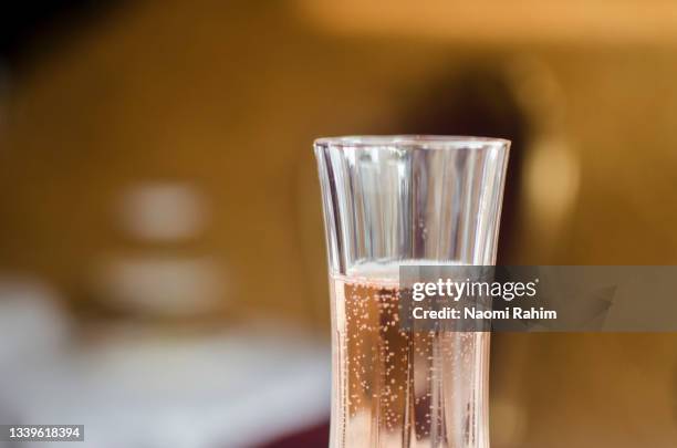 close-up of champagne in an elegant crystal flute, in a gold-colored interior - crystal glassware stock pictures, royalty-free photos & images