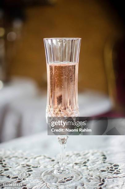 crystal champagne flute, served on an embroidered white tablecloth, in an elegant restaurant - crystal glasses stockfoto's en -beelden