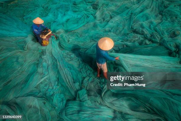 two men is fixing fishing net - nha trang stock pictures, royalty-free photos & images