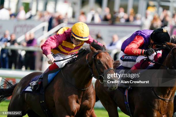 David Egan riding Bayside Boy win The Champagne Stakes from Frankie Dettori and Reach For The Moon at Doncaster Racecourse on September 11, 2021 in...