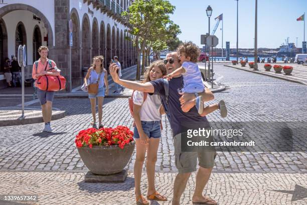 vater mit zwei kindern, die spaß haben und ein selfie machen - ponta delgada azores portugal stock-fotos und bilder