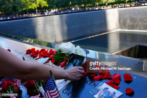 Monica Iken places a photo along with flowers on the name of her husband Michael Patrick Iken during the annual 9/11 Commemoration Ceremony at the...