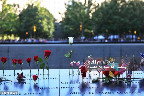 Flowers and U.S. Flags are left on the names of victims during the annual 9/11 Commemoration Ceremony at the National 9/11 Memorial and Museum on...