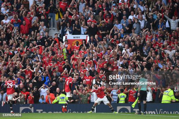Bruno Fernandes of Manchester United celebrates after scoring their side's third goal as fans celebrate during the Premier League match between...
