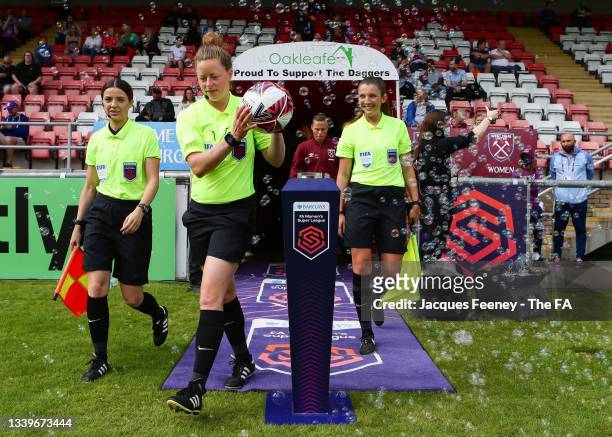 Kirsty Dowle, the match referee leads out assistant referees, Emily Carney and Melissa Burgin and the West Ham United squad prior to the Barclays FA...