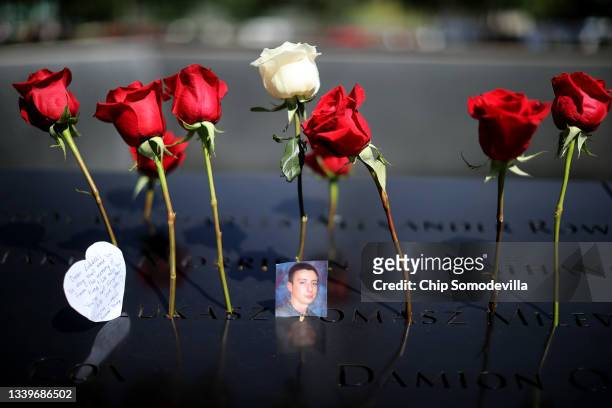 Flowers and photographs are placed into the inscribed names of the victims of the 9/11 attacks and in the 1993 World Trade Center bombing during the...