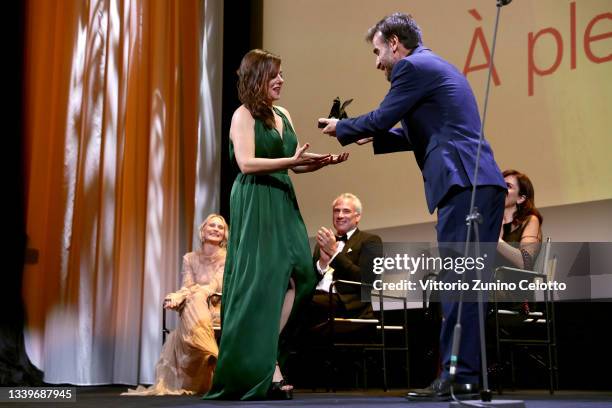 Laure Calamy receives the Orizzonti Best Actress Award for "A Plein Temps" from Orizzonti Jury member Shahram Mokri during the closing ceremony...