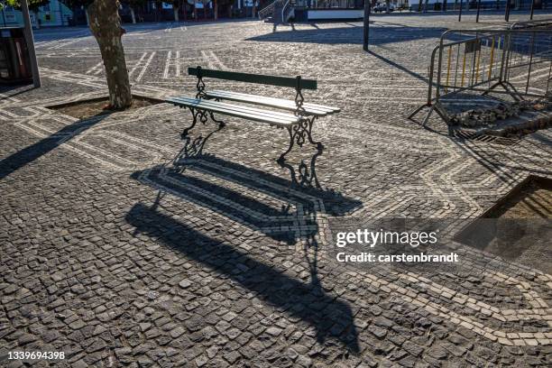 public bench at a city square in evening sun - ponta delgada stock pictures, royalty-free photos & images