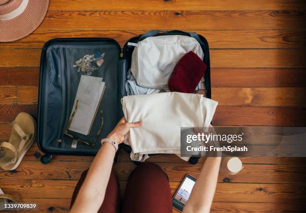 a caucasian woman packing a suitcase from above on the wooden floor on a holiday or a business trip - carry on luggage stock pictures, royalty-free photos & images