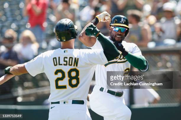 Starling Marte of the Oakland Athletics celebrates with Matt Olson after hitting a solo home run in the bottom of the first inning against the Texas...