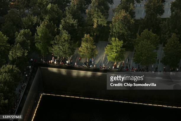 Light bounces off of nearby buildings to light the edge of the north pool at the National 9/11 Memorial and Museum on September 11, 2021 in New York...