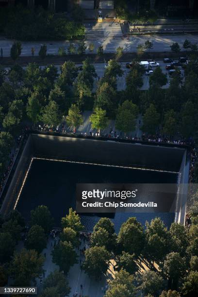 Light bounces off of nearby buildings to light the edge of the north pool at the National 9/11 Memorial and Museum on September 11, 2021 in New York...