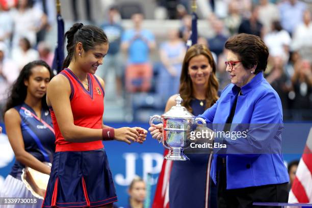 Emma Raducanu of Great Britain is awarded the championship trophy by Billie Jean King after defeating Leylah Annie Fernandez of Canada during their...