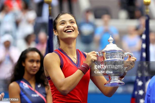 Emma Raducanu of Great Britain celebrates with the championship trophy after defeating Leylah Annie Fernandez of Canada during their Women's Singles...