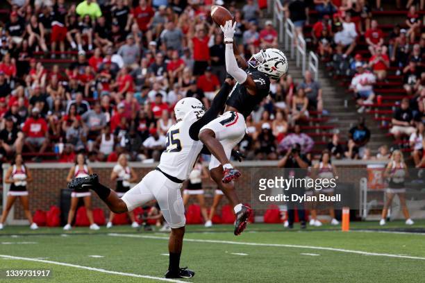 Tre Tucker of the Cincinnati Bearcats makes a catch while being defended by Frank Coppet of the Murray State Racers in the fourth quarter at Nippert...