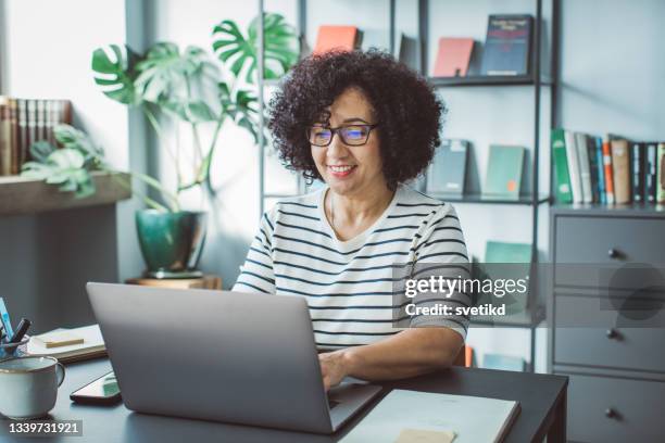 book publisher at office - mature reading computer bildbanksfoton och bilder