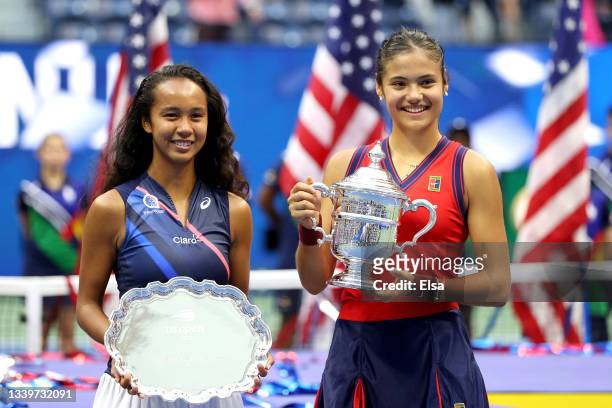 Leylah Annie Fernandez of Canada holds the runner-up trophy as Emma Raducanu of Great Britain celebrates with the championship trophy after their...