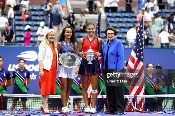 Leylah Annie Fernandez of Canada holds the runner-up trophy as Emma Raducanu of Great Britain celebrates with the championship trophy alongside...