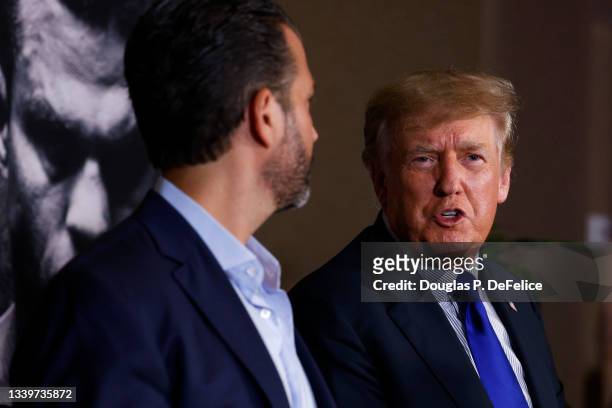 Former US President Donald Trump and Donald Trump Jr talk prior to the fight between Evander Holyfield and Vitor Belfort during Evander Holyfield vs....